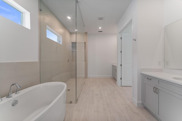 bathroom with vanity, hardwood / wood-style flooring, tile walls, and separate shower and tub