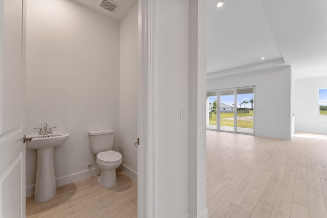 bathroom with wood-type flooring and toilet