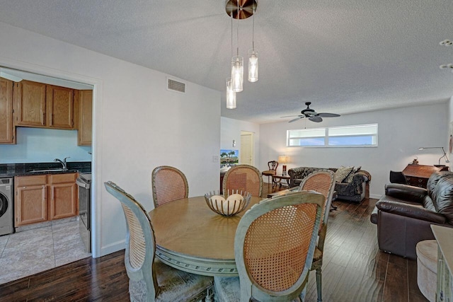 dining room with ceiling fan, sink, dark wood-type flooring, and washer / dryer