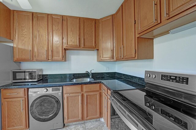 kitchen featuring ceiling fan, light tile patterned flooring, sink, washer / clothes dryer, and appliances with stainless steel finishes