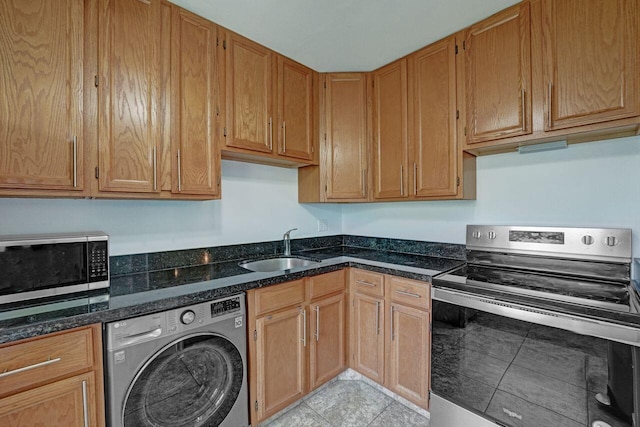 interior space with light tile patterned floors, washer / clothes dryer, and sink