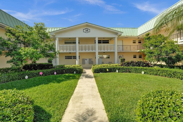 exterior space featuring a standing seam roof, a front yard, metal roof, and stucco siding