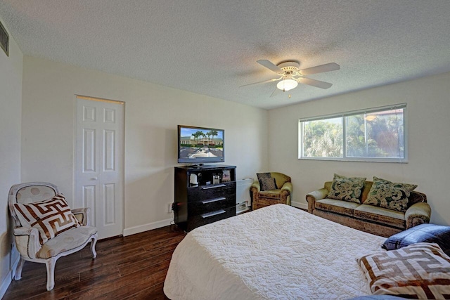 bedroom with a textured ceiling, dark hardwood / wood-style floors, and ceiling fan