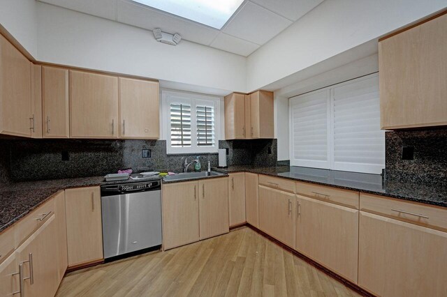 kitchen featuring light hardwood / wood-style floors, light brown cabinets, sink, and stainless steel dishwasher