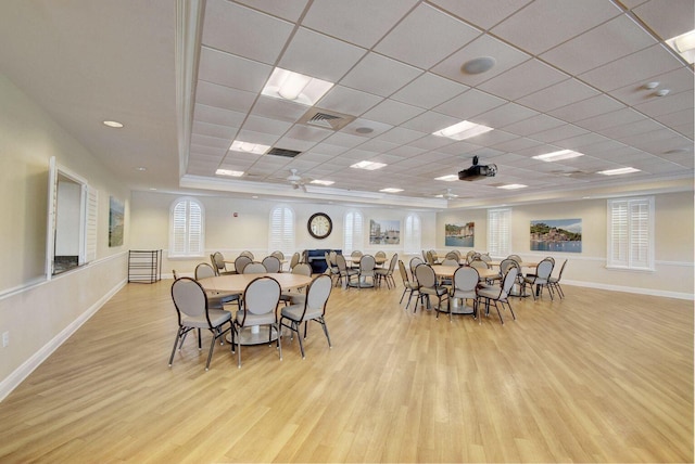 dining room with a paneled ceiling, ceiling fan, and light hardwood / wood-style flooring