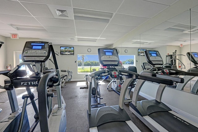 workout area featuring a drop ceiling, visible vents, and baseboards