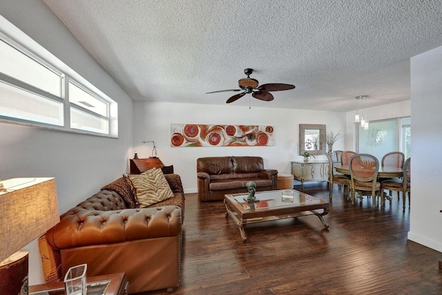 living room featuring ceiling fan with notable chandelier, dark hardwood / wood-style flooring, and plenty of natural light