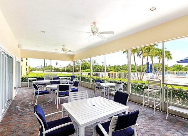 sunroom featuring a ceiling fan