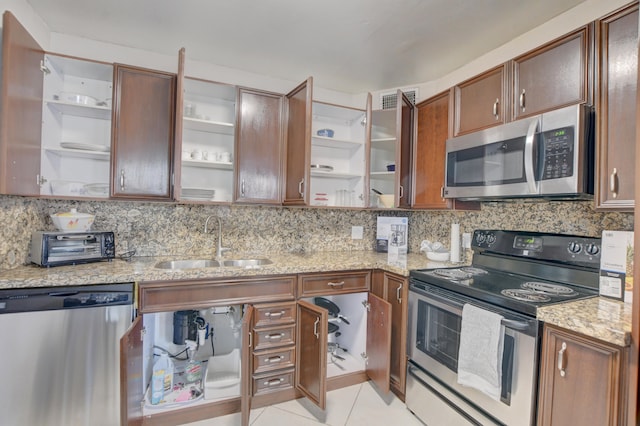 kitchen featuring tasteful backsplash, sink, appliances with stainless steel finishes, and light tile patterned floors