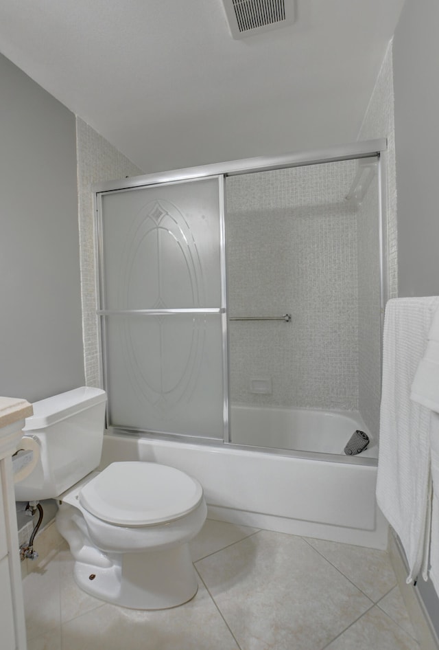 bathroom featuring combined bath / shower with glass door, toilet, and tile patterned floors