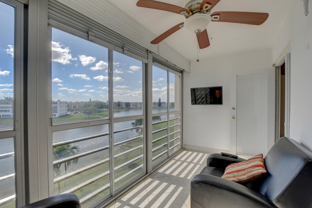 sunroom / solarium featuring a water view and ceiling fan