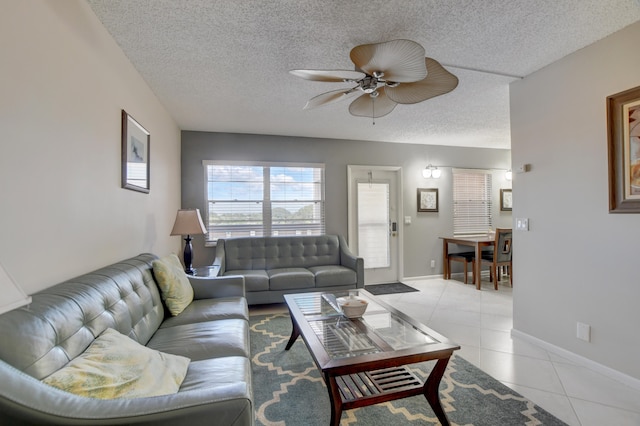 tiled living room with a textured ceiling and ceiling fan