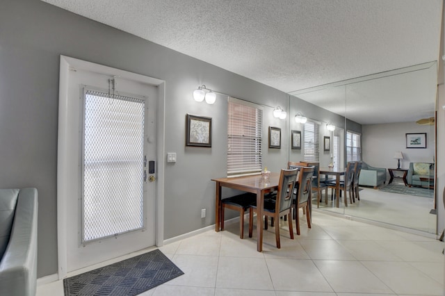 kitchen with light tile patterned flooring, appliances with stainless steel finishes, light stone countertops, and backsplash