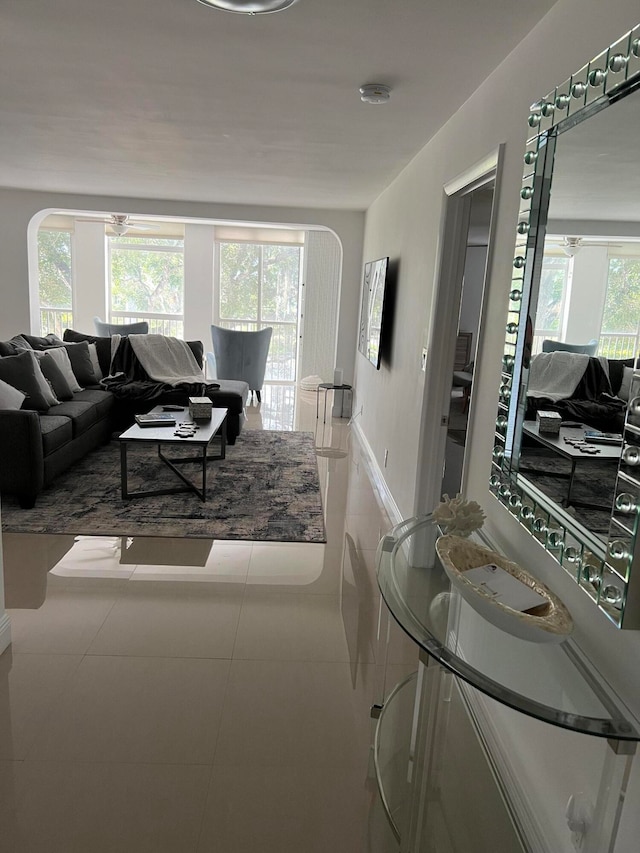 living room with ceiling fan, tile patterned flooring, and a healthy amount of sunlight