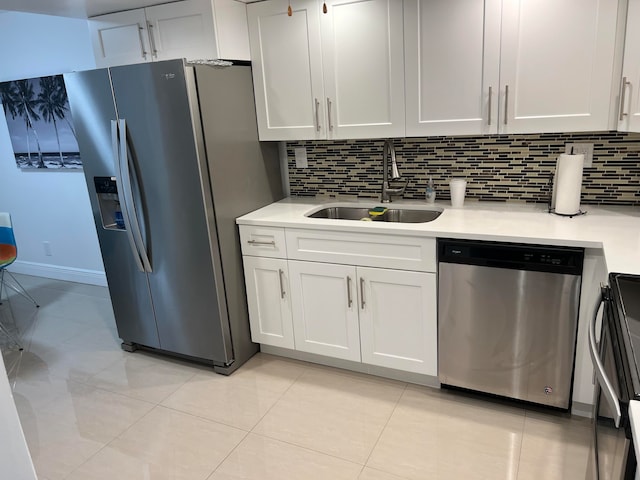 kitchen with stainless steel appliances, white cabinets, sink, and tasteful backsplash