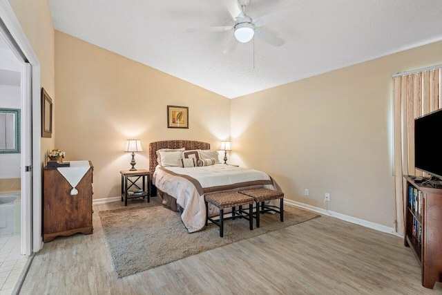 bedroom featuring light hardwood / wood-style floors, vaulted ceiling, ceiling fan, and a textured ceiling