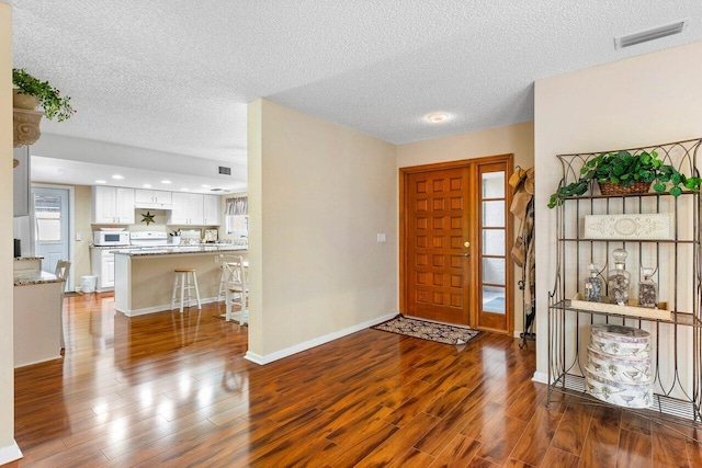 entrance foyer with a textured ceiling and wood-type flooring