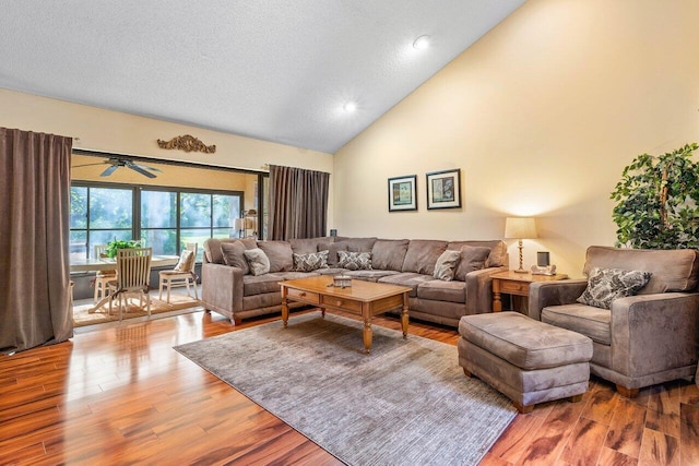 living room featuring hardwood / wood-style floors, ceiling fan, and high vaulted ceiling