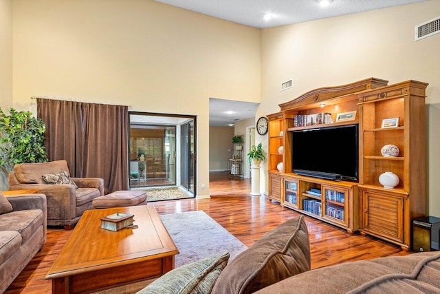 living room with dark hardwood / wood-style flooring and a high ceiling