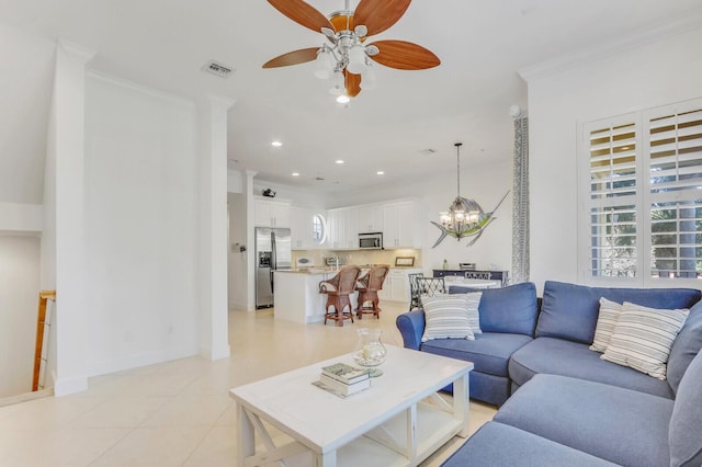 living room featuring ceiling fan with notable chandelier, light tile patterned flooring, and crown molding