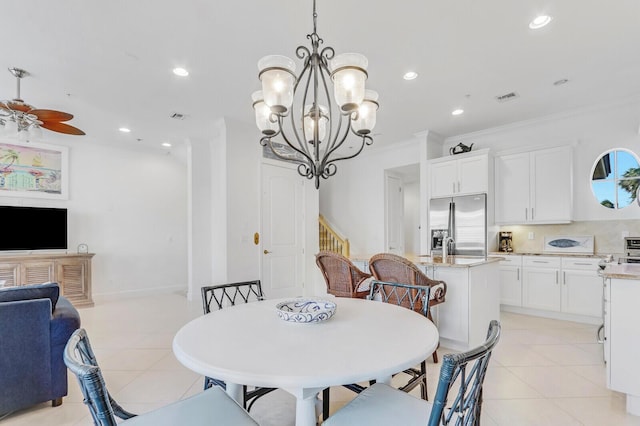 dining area with crown molding, light tile patterned flooring, and ceiling fan with notable chandelier