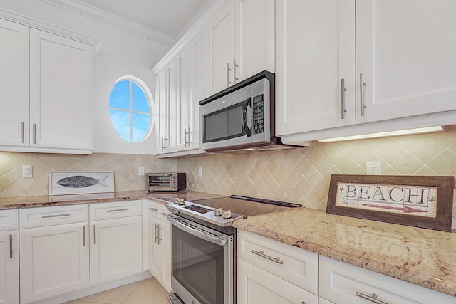 kitchen featuring stainless steel appliances, light tile patterned floors, light stone counters, white cabinets, and ornamental molding