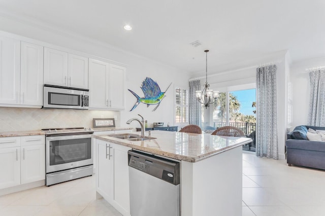 kitchen featuring sink, white cabinets, stainless steel appliances, and a center island with sink