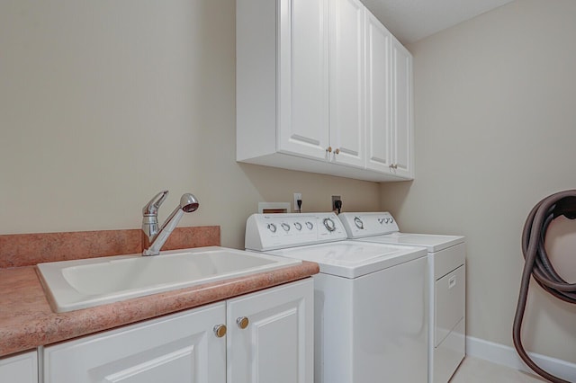 laundry area featuring cabinets, independent washer and dryer, sink, and light tile patterned floors