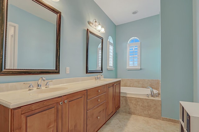 bathroom featuring tiled bath, tile patterned flooring, and vanity