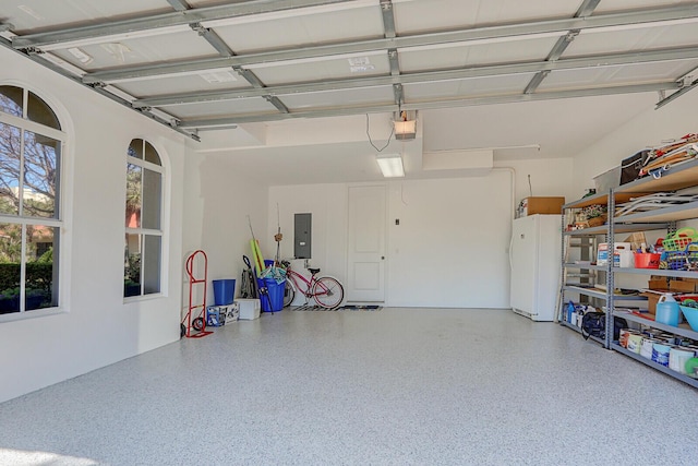 garage with a garage door opener and electric panel