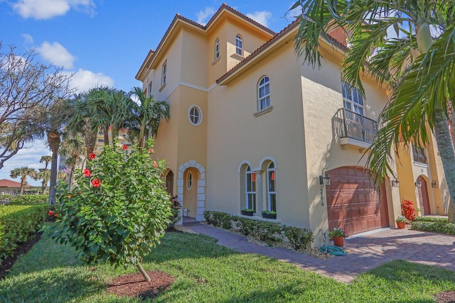 view of home's exterior featuring a garage, a yard, and a balcony