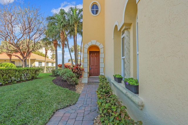 entrance to property featuring a lawn