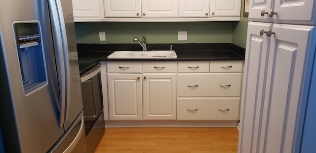 kitchen featuring white cabinetry, stainless steel refrigerator with ice dispenser, sink, and light hardwood / wood-style flooring