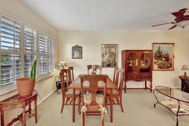 dining area with a wealth of natural light, a textured ceiling, light carpet, and ceiling fan