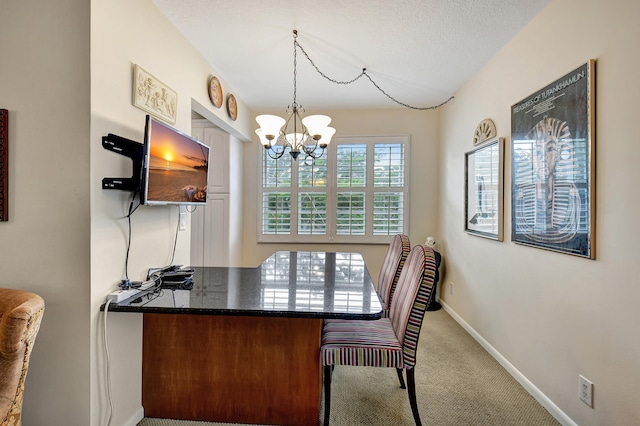 dining space featuring an inviting chandelier, carpet flooring, and a textured ceiling