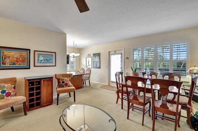 carpeted dining space with a chandelier and a textured ceiling