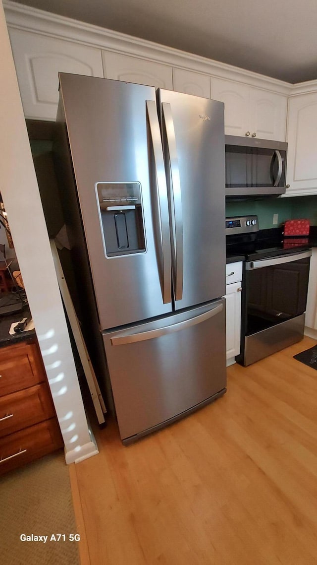 kitchen with white cabinetry, light hardwood / wood-style flooring, and appliances with stainless steel finishes