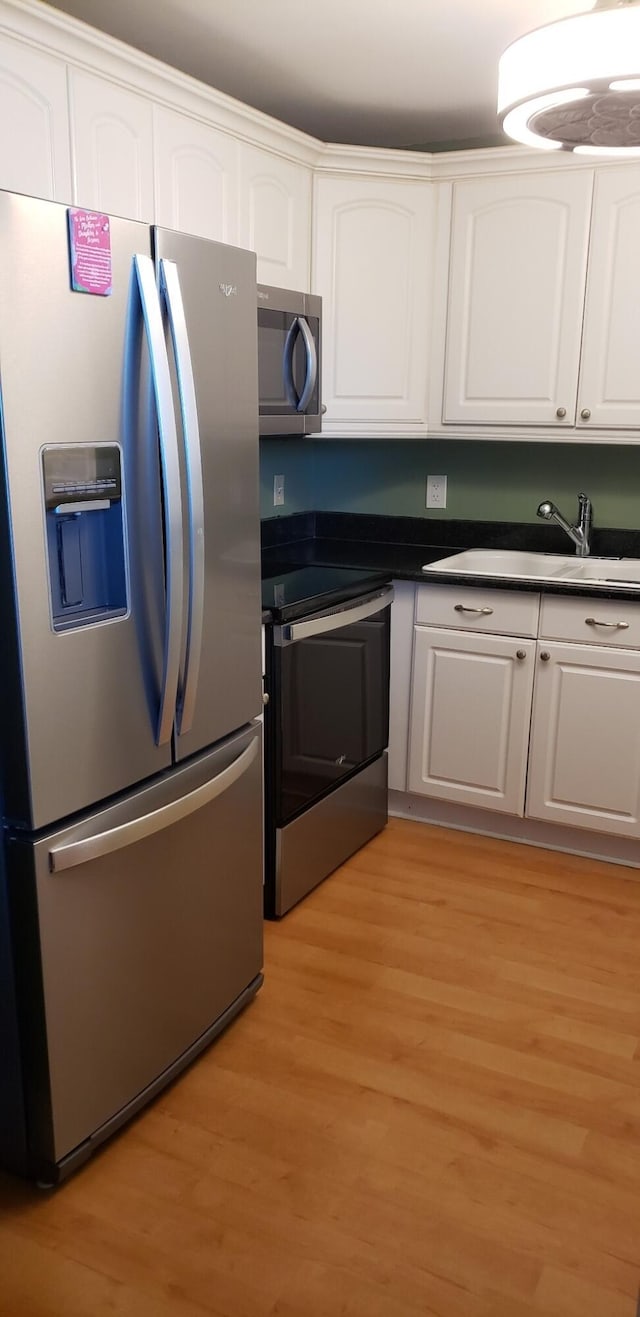 kitchen featuring white cabinets, light hardwood / wood-style floors, sink, and appliances with stainless steel finishes