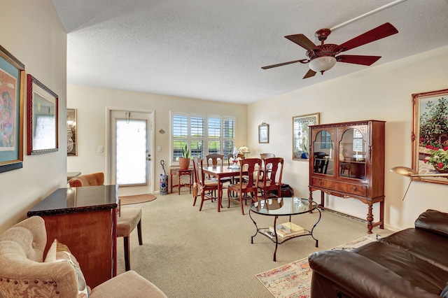 carpeted living room featuring a textured ceiling and ceiling fan