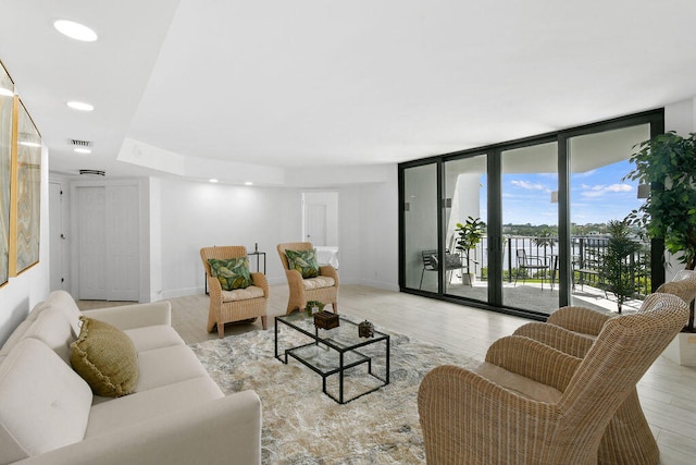 living room featuring floor to ceiling windows and light wood-type flooring