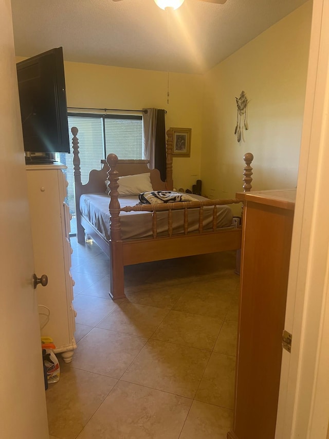 tiled bedroom featuring vaulted ceiling