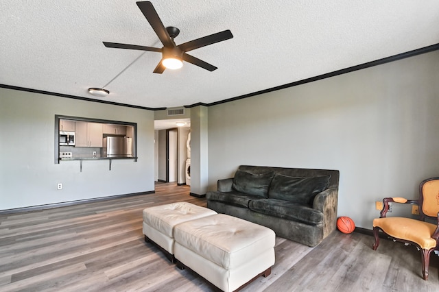 living room with a textured ceiling, crown molding, ceiling fan, and hardwood / wood-style flooring