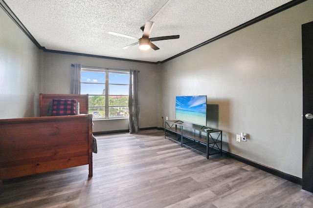 bedroom with a textured ceiling, wood-type flooring, and ceiling fan