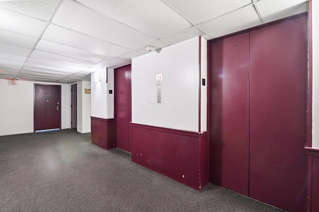 empty room featuring a drop ceiling and elevator