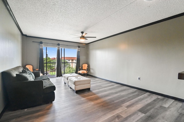 living room with ornamental molding, hardwood / wood-style floors, ceiling fan, and a textured ceiling