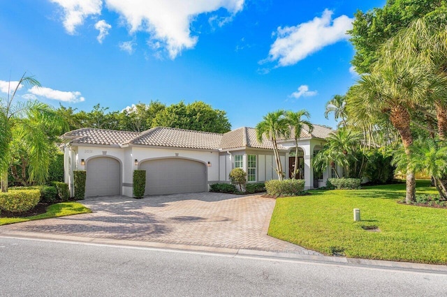 mediterranean / spanish-style home featuring a garage and a front yard