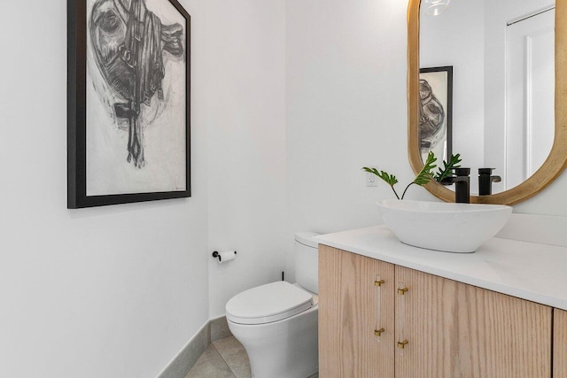 bathroom with tile floors, vanity, and toilet