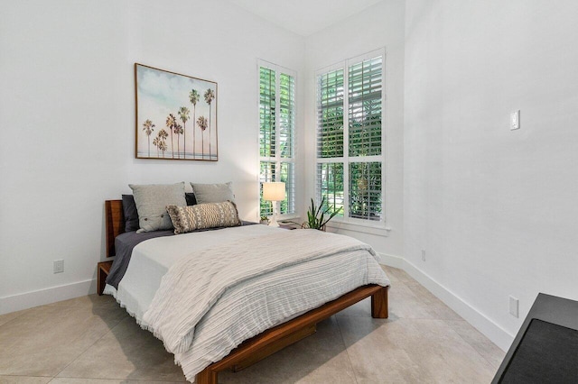 bedroom featuring multiple windows and light tile floors