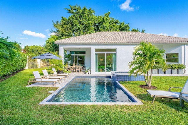 back of property with a fenced in pool, a patio area, pool water feature, and a lawn