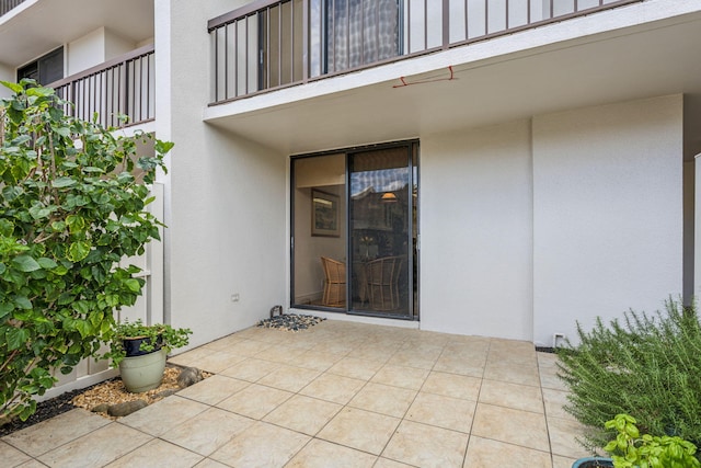 entrance to property featuring a patio and a balcony